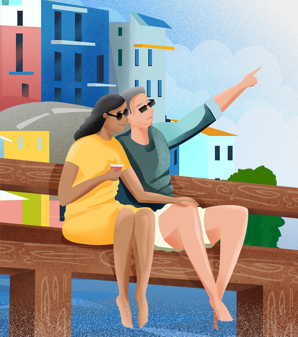 savor - a couple sitting on a pier enjoying the ocean view